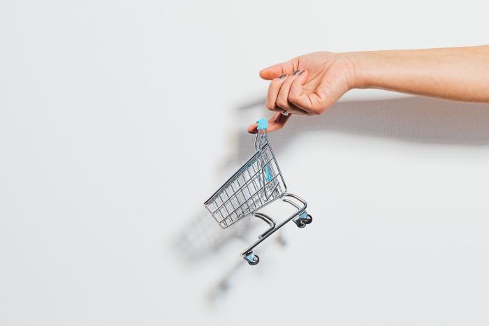 Persona cargando un carrito de compras