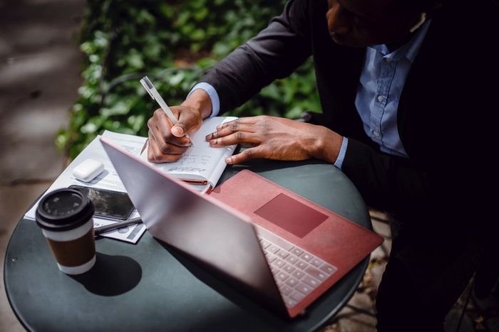 Hombre anotando en libreta Arma tu estrategia SEO, Paso 1: Define los objetivos de tu estrategia SEO